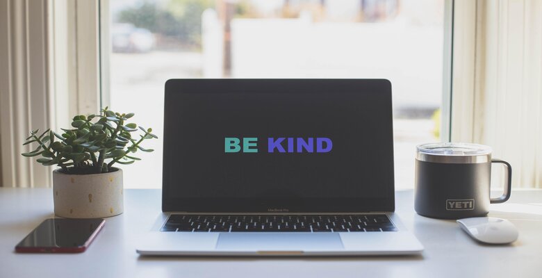 A laptop saying to be kind