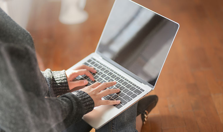 Woman typing on laptop.