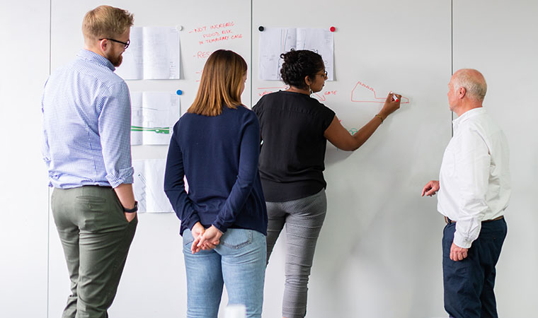 Team writing on a whiteboard.