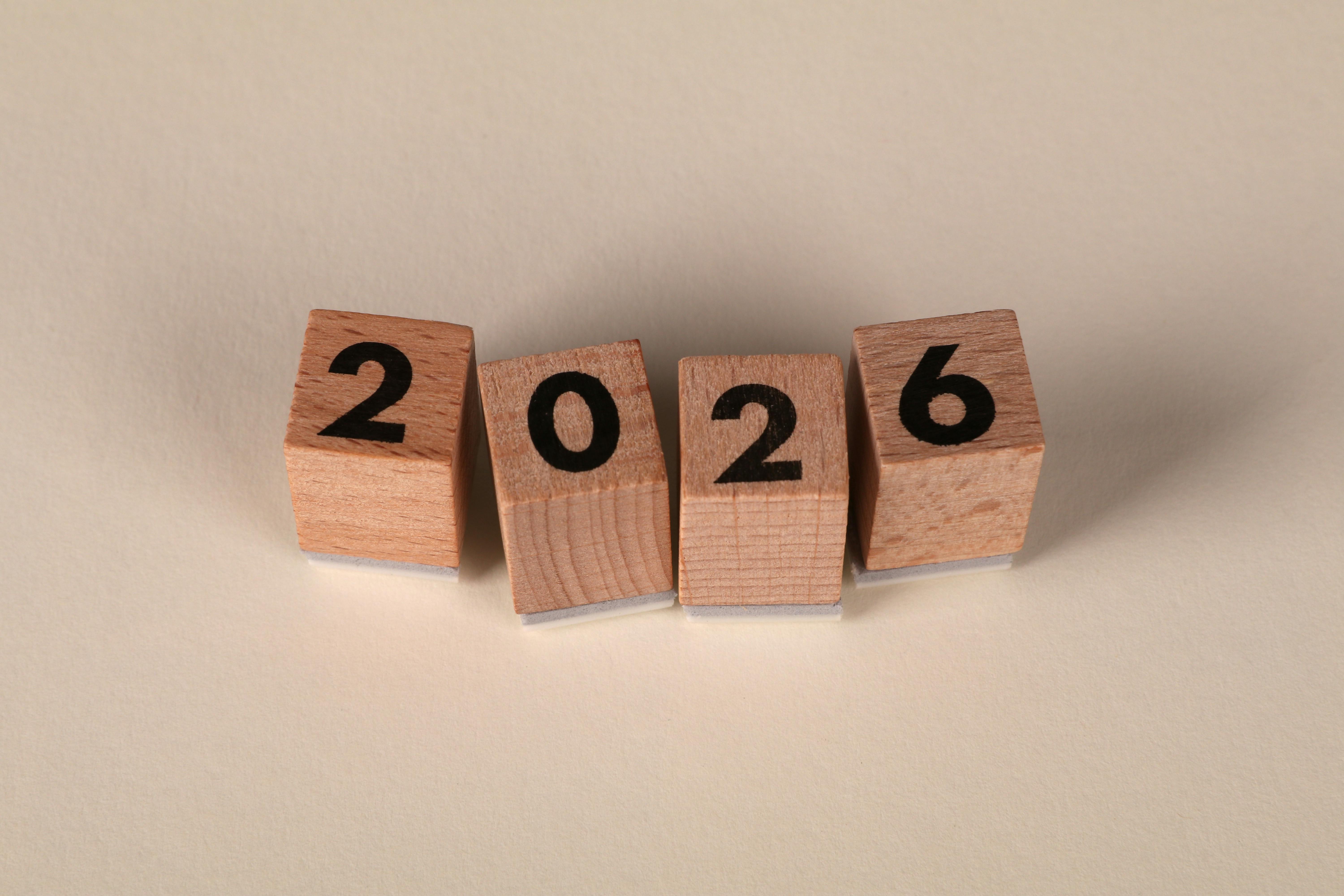 4 wooden blocks with black text on them that spells out 2026