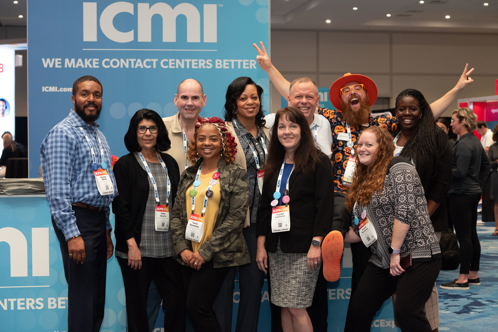 a group of happy attendees on the show floor at ICMI's Contact Center Expo with the event emcee, Nate Brown
