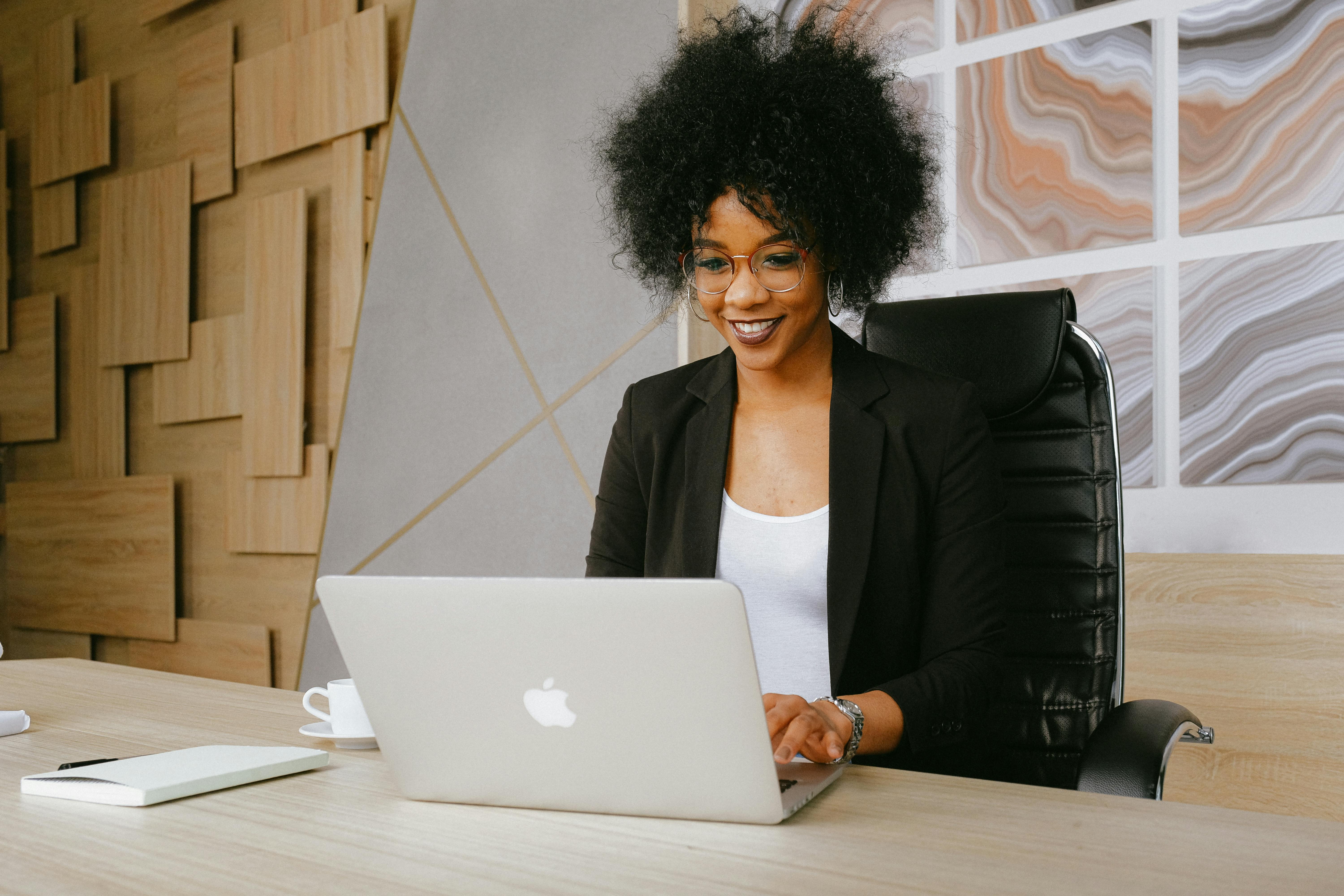 Happy professional participating in a virtual coffee meetup on her computer.