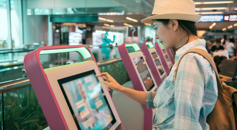 Image illustrating a woman using a self-service kiosk