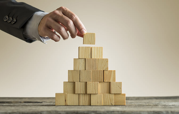 Businessman building a pyramid.