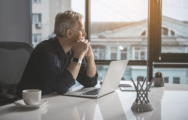 Businessman looking wistfully out a window.