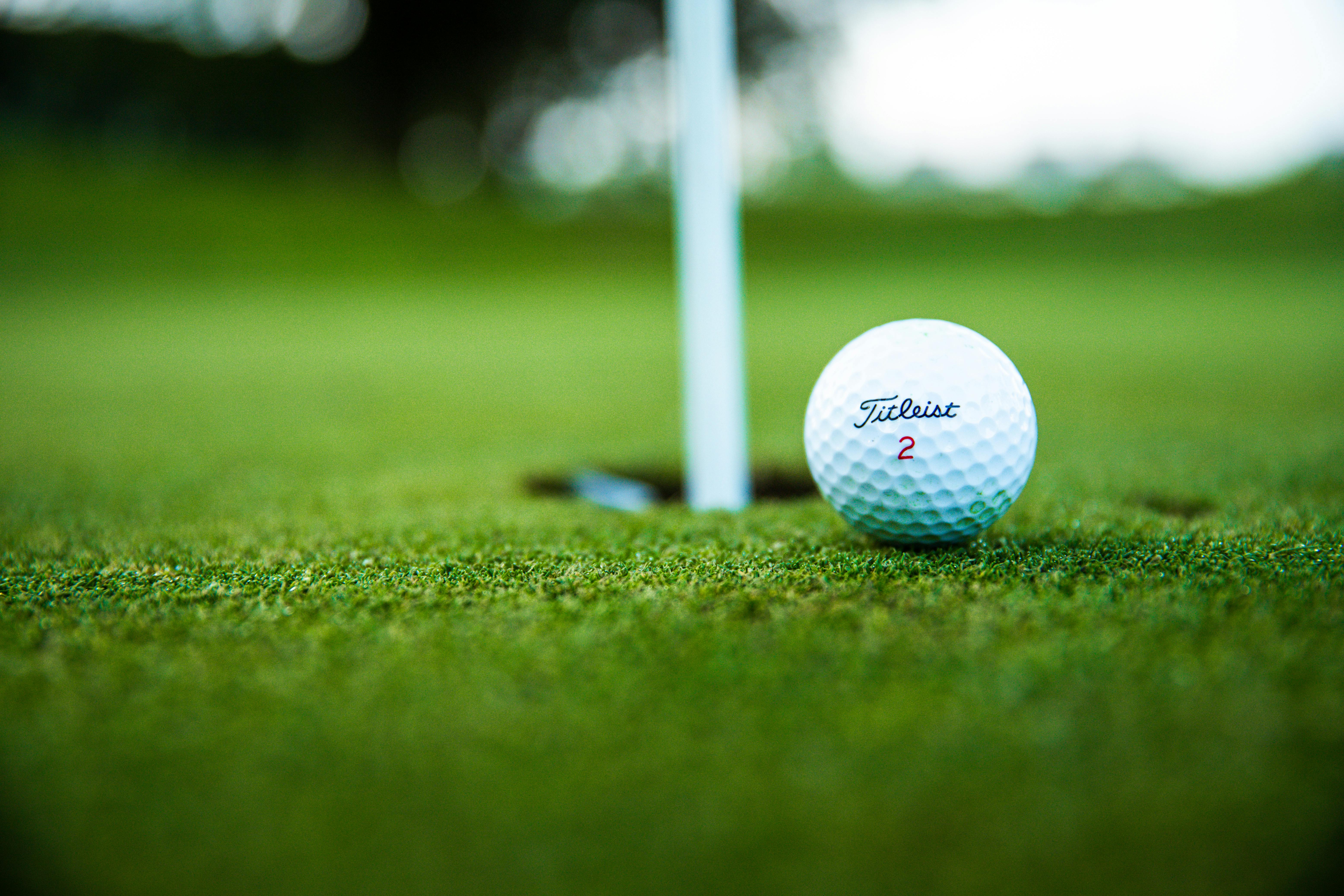 A golf ball on a putting green near the hole