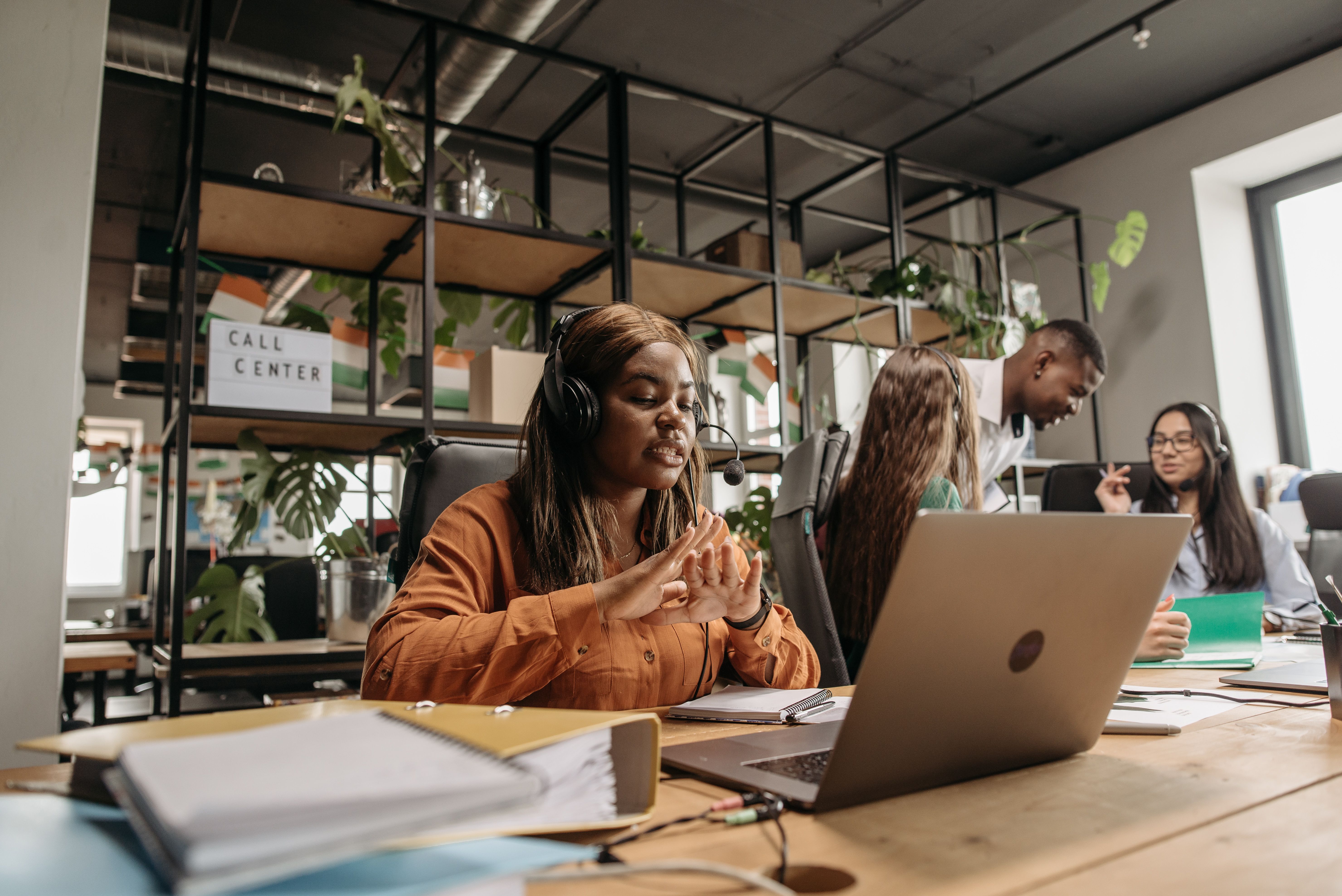 Customer service professional using a laptop and headset, representing the balance between AI efficiency and human connection in customer experience.