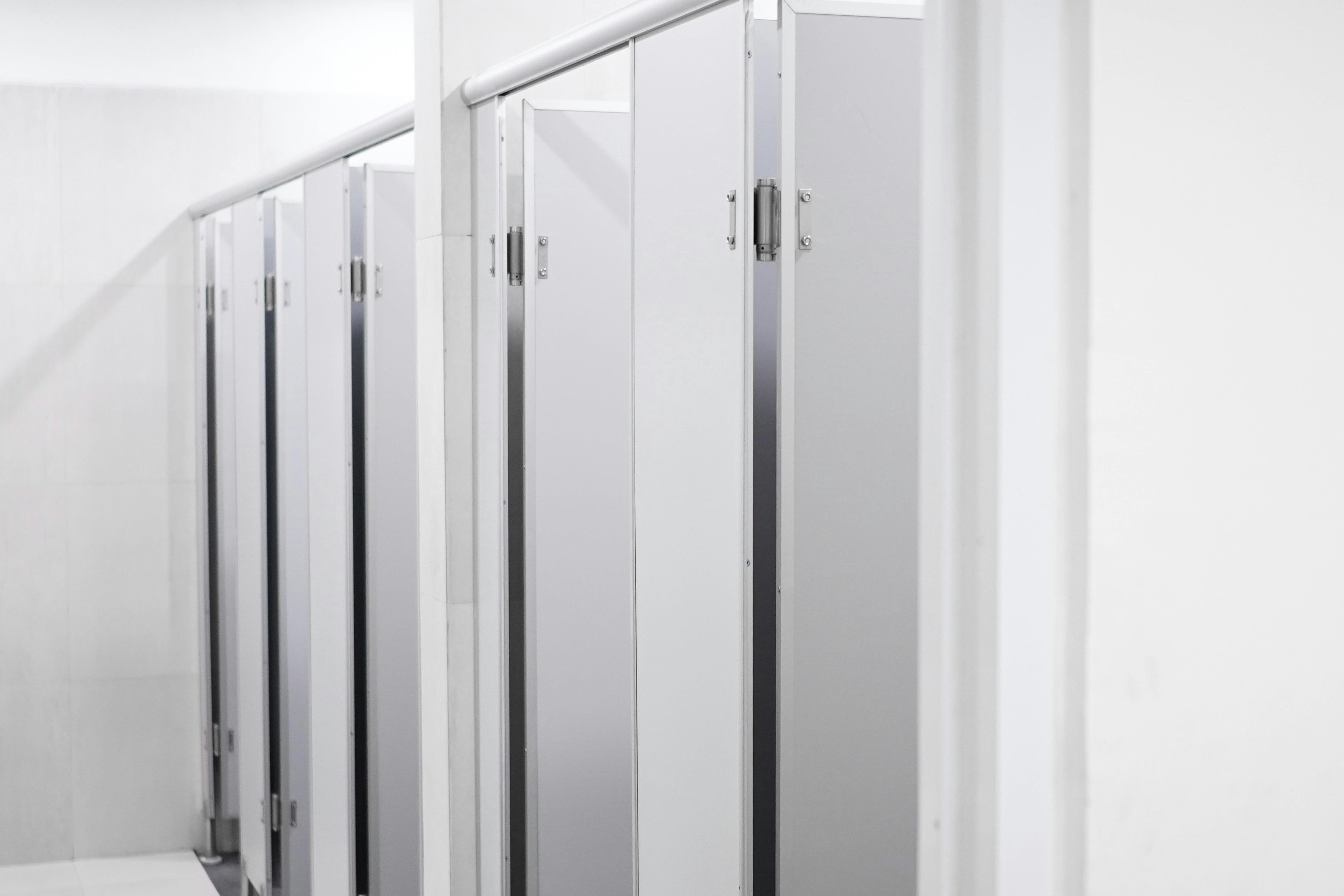 Close-up shot of clean and well-maintained toilet partitions in an airport restroom, symbolizing service excellence and attention to detail.