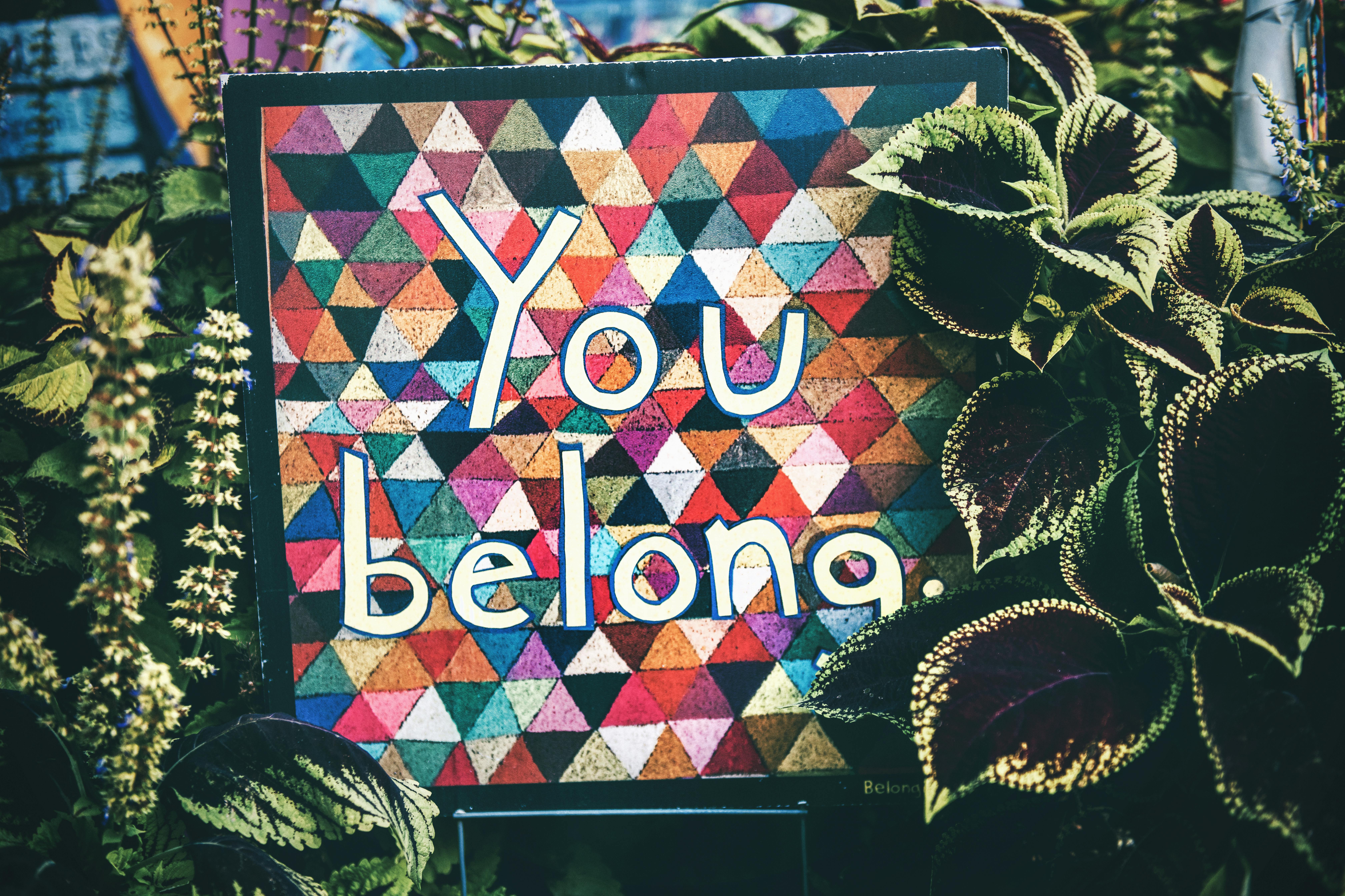 An art piece surrounded by lush green plants, symbolizing growth, inclusivity, and connection in the workplace.