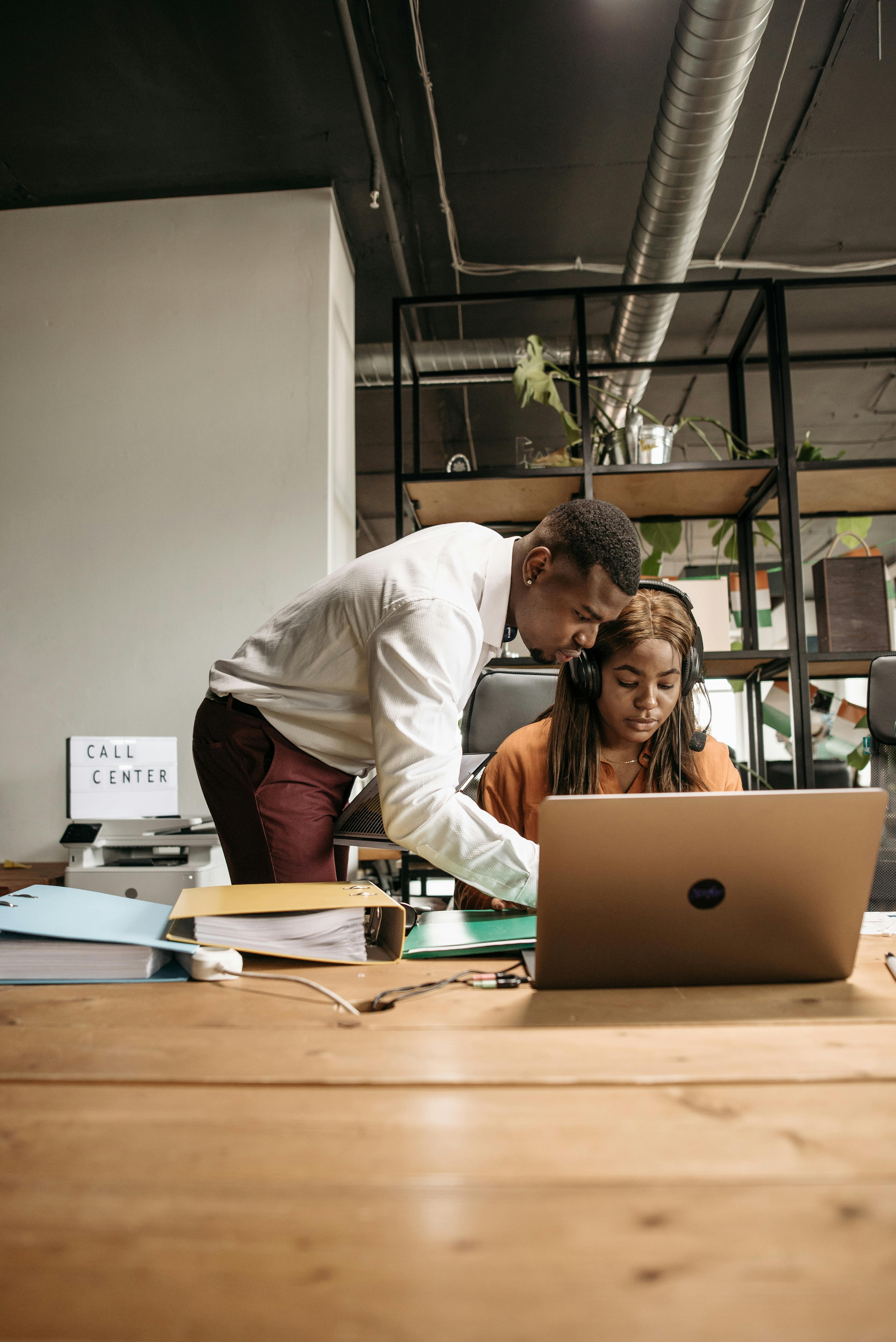 A professional setting where a boss is engaging in a focused conversation with an employee, symbolizing collaboration and alignment in a Quality Assurance program.