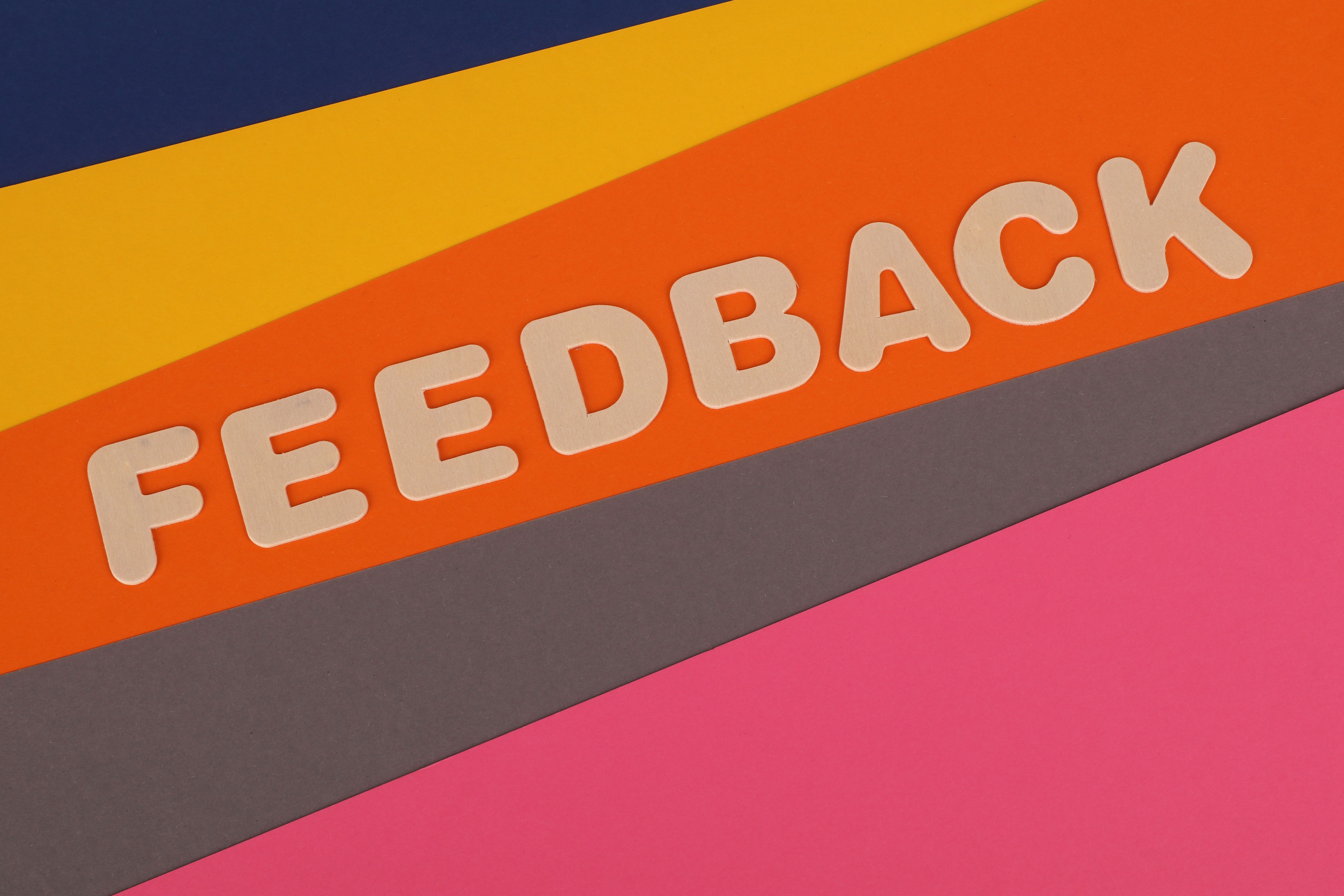 Colorful wallpaper featuring a feedback sign, symbolizing the importance of internal customer satisfaction and communication in workforce management.