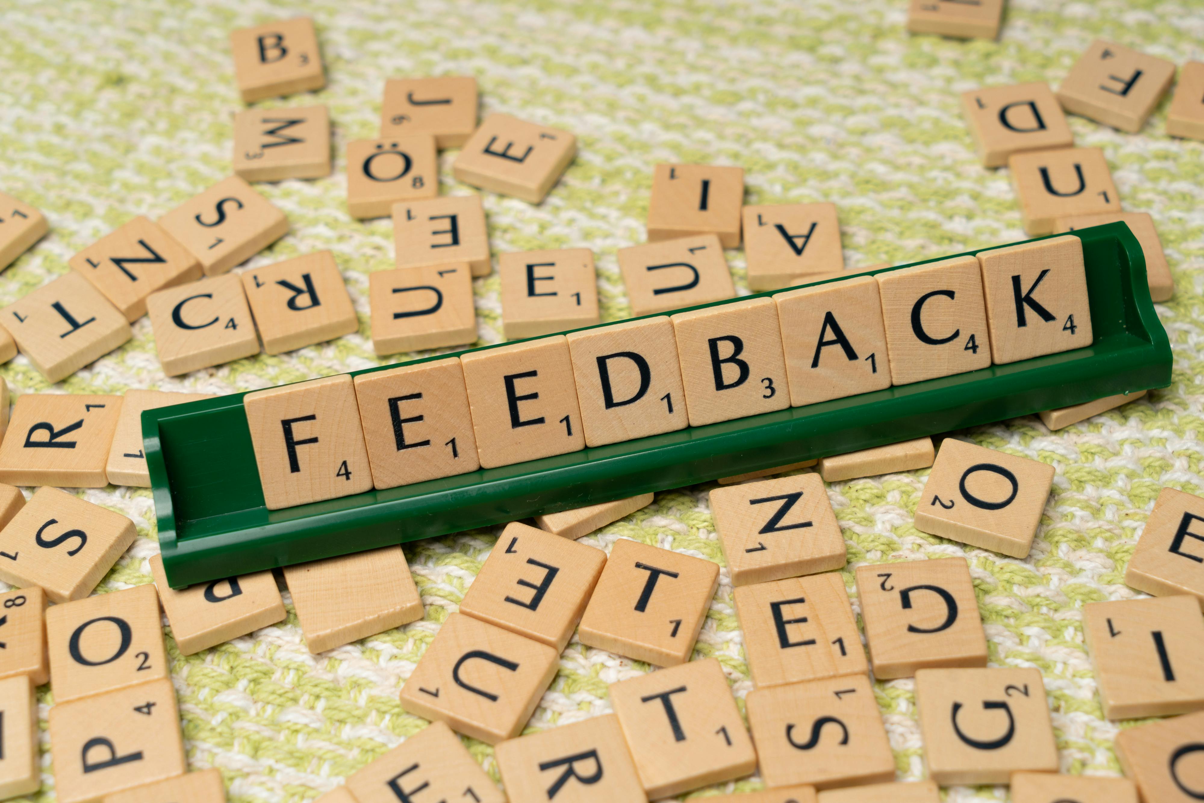 ustomer feedback concept with wooden letter tiles, representing contact center CX and Voice of the Customer (VOC) program improvement.