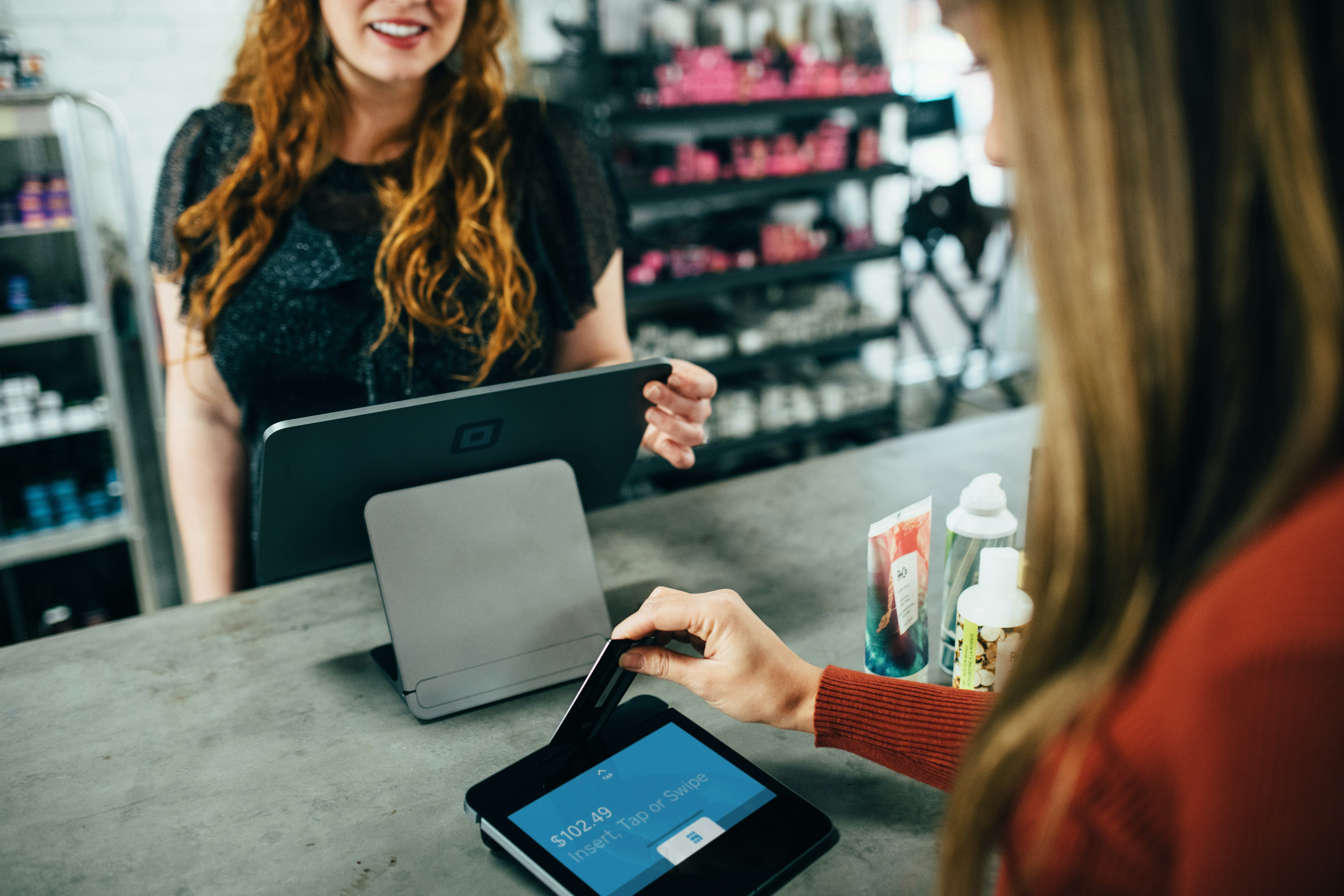 a woman checking out at the store and having a friendly interaction with the cashier