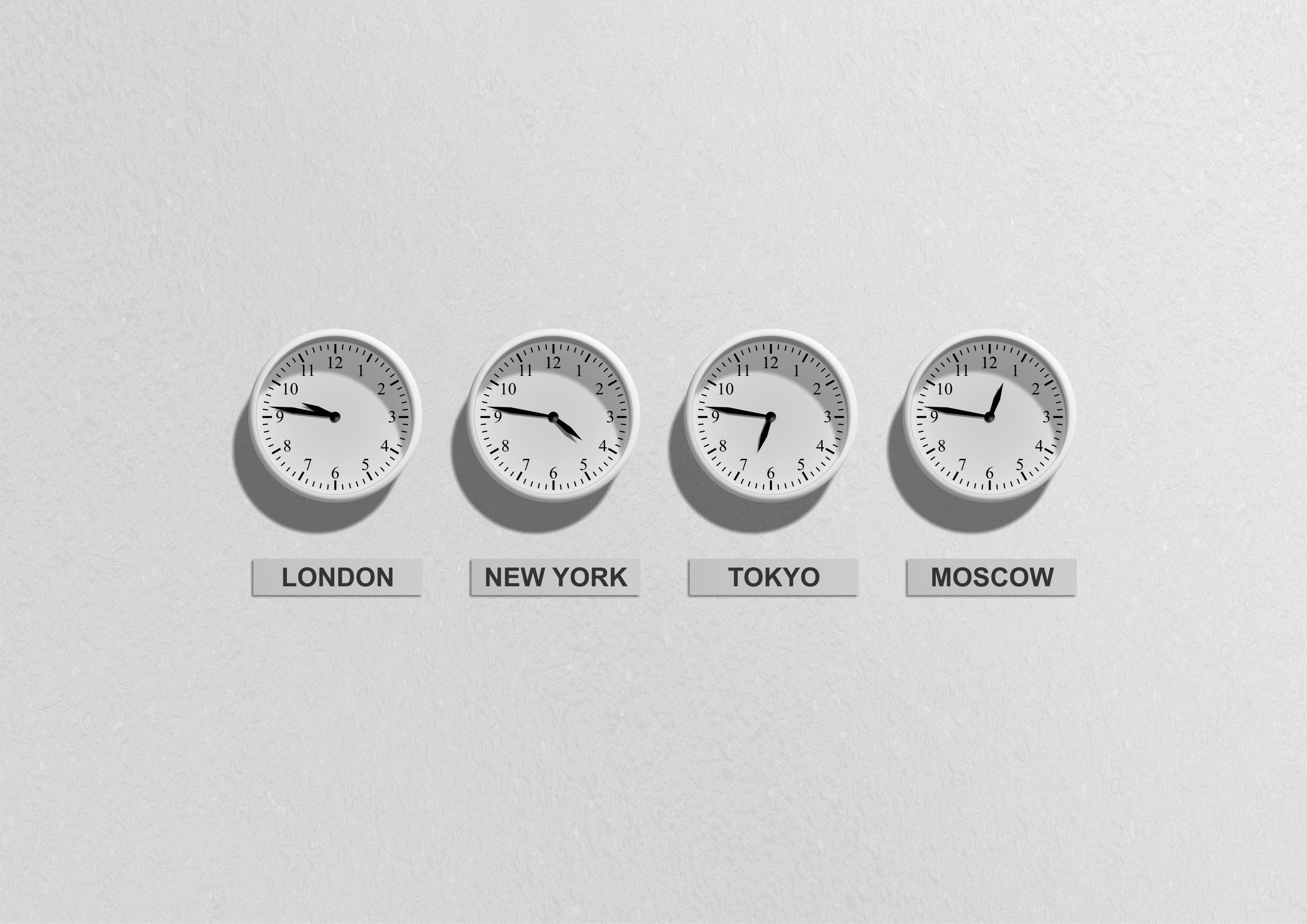 Wall clocks displaying time zones for London, New York, Tokyo, and Moscow, symbolizing global real-time management and workforce optimization.