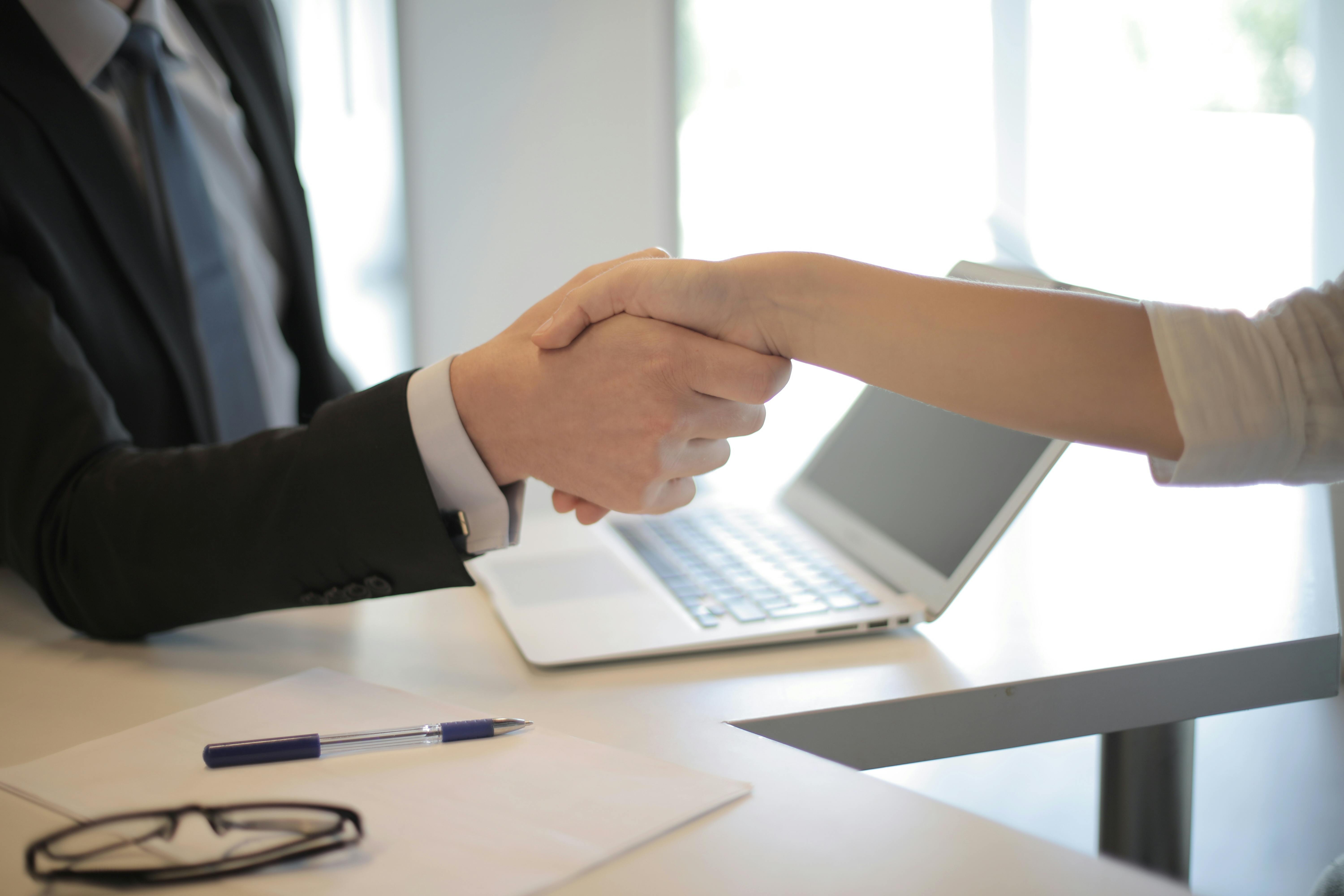 man and woman shaking hands during a job interview