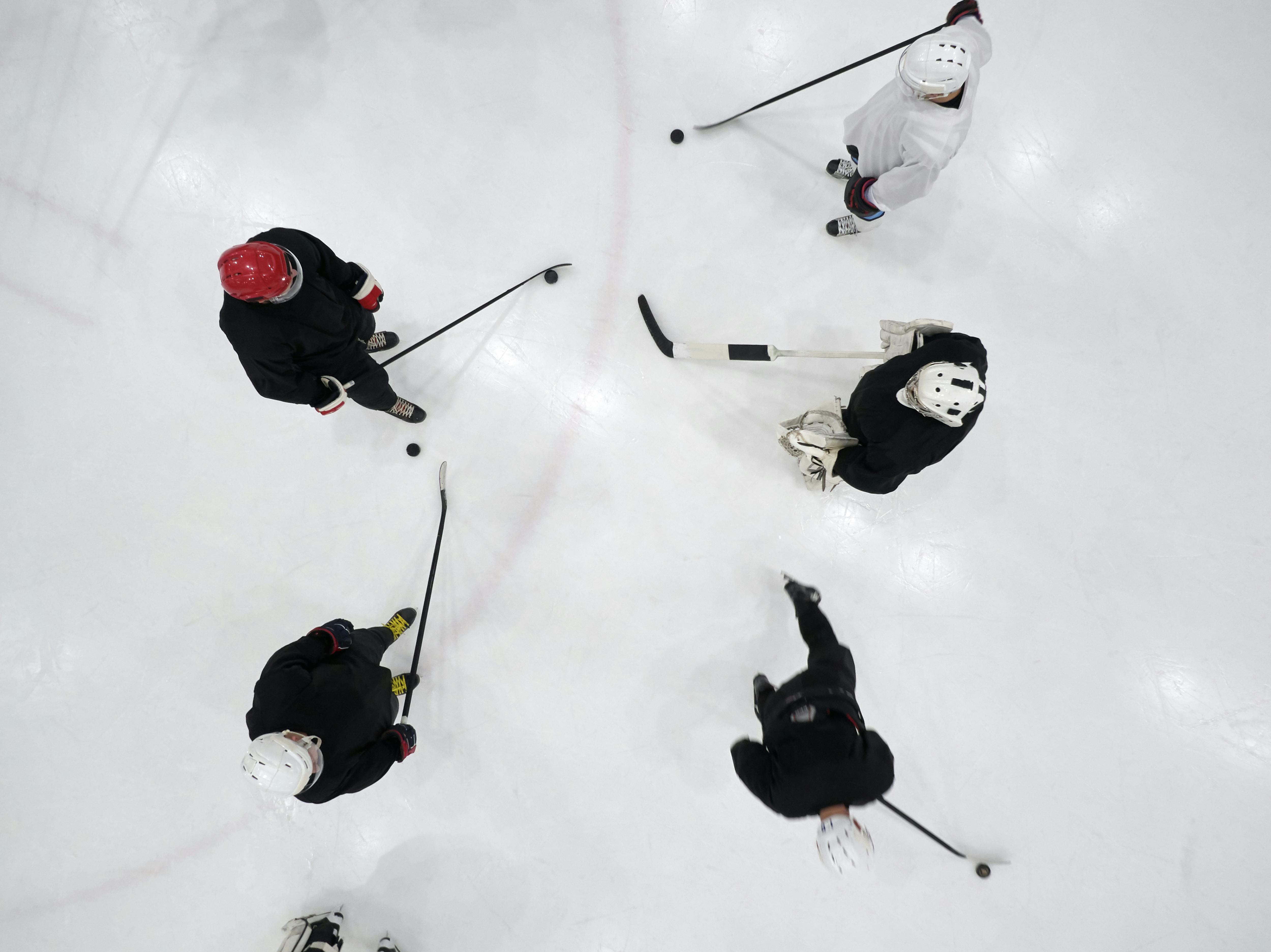 Top view of hockey players wearing skullcaps, symbolizing adaptability and dynamic forecasting methods in high-variability environments.