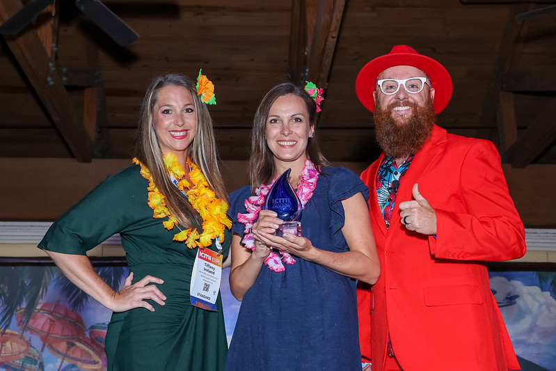 Nate Brown with 2 ICMI Global Contact Center Awards winners posing with their trophy