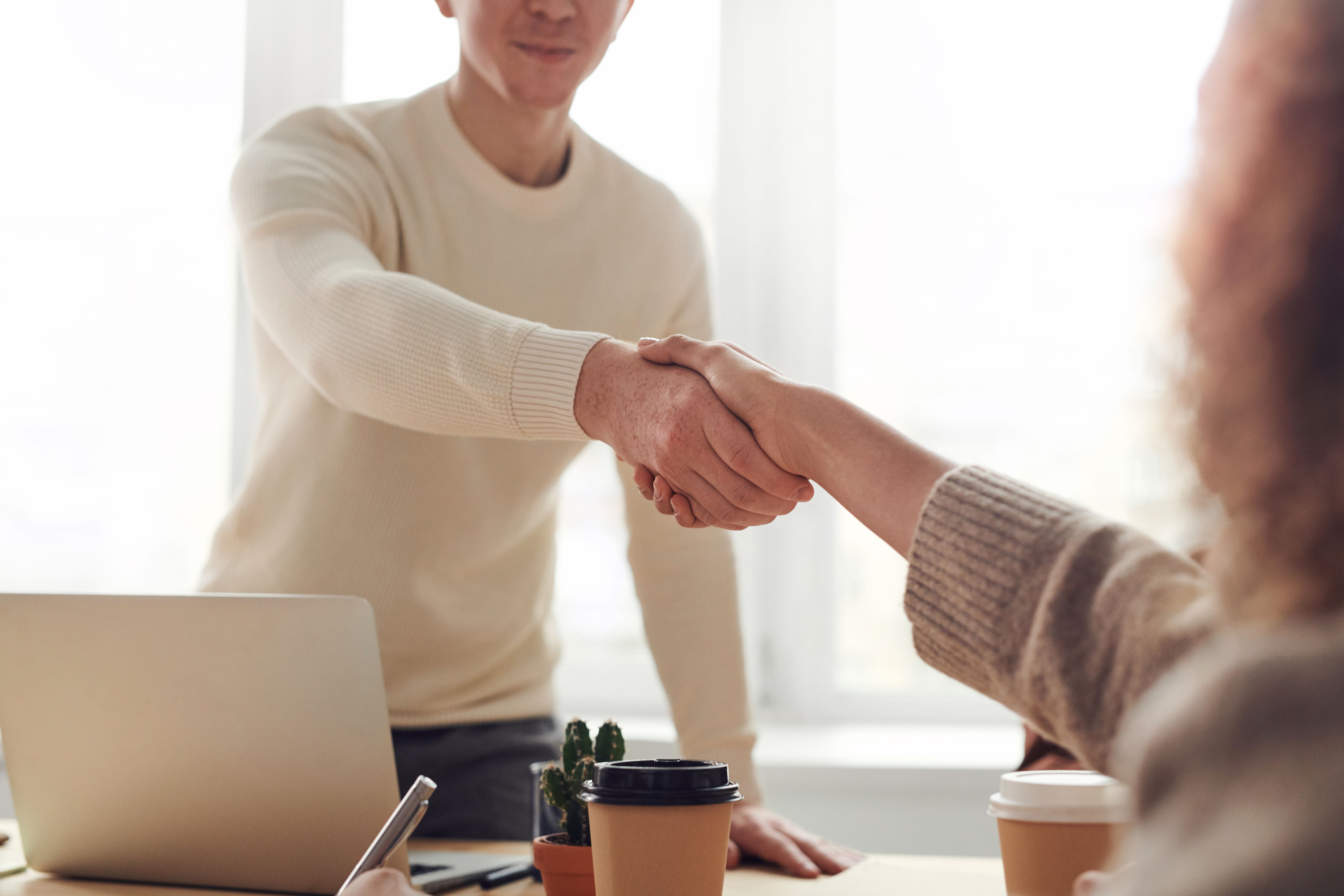 A man and woman sitting at a table during a job interview, thoughtfully discussing service culture and the importance of mindset in customer experience.