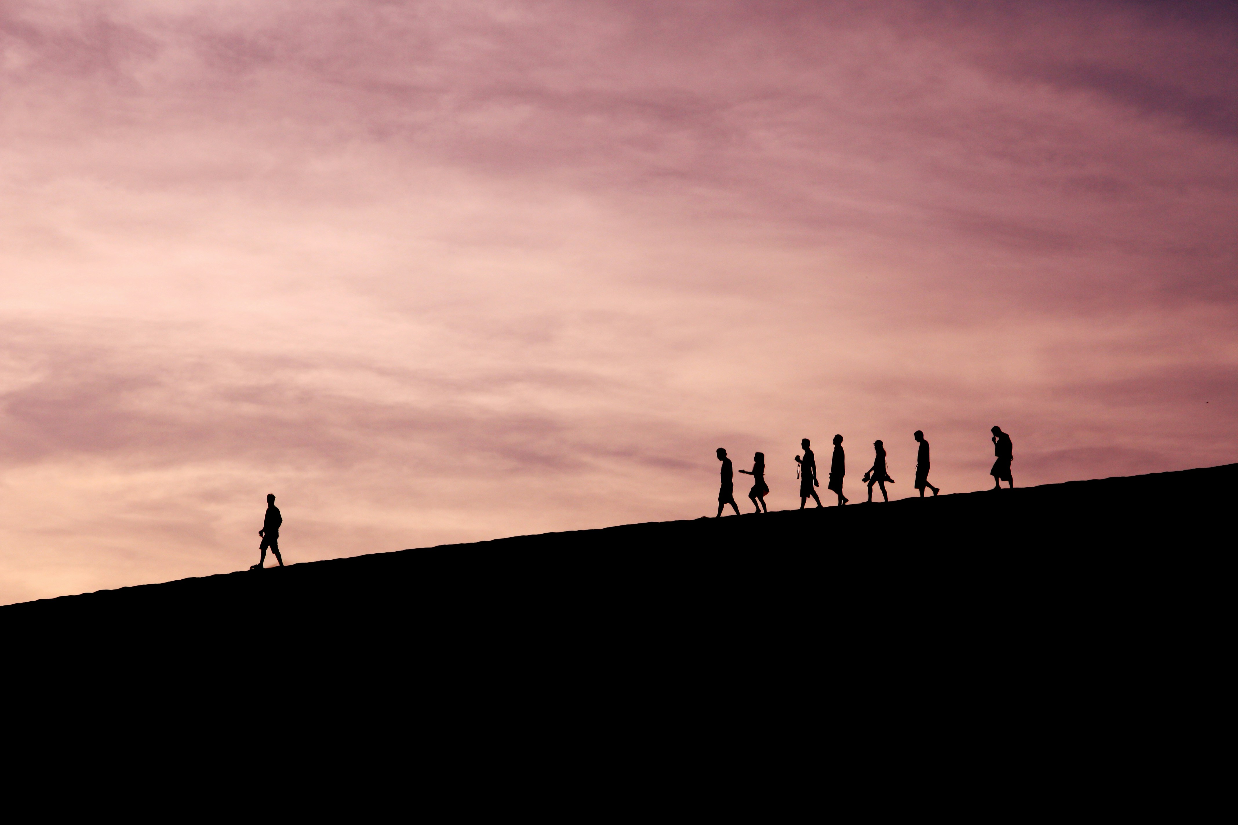 a group of people follow their leader on a hike in the mountains
