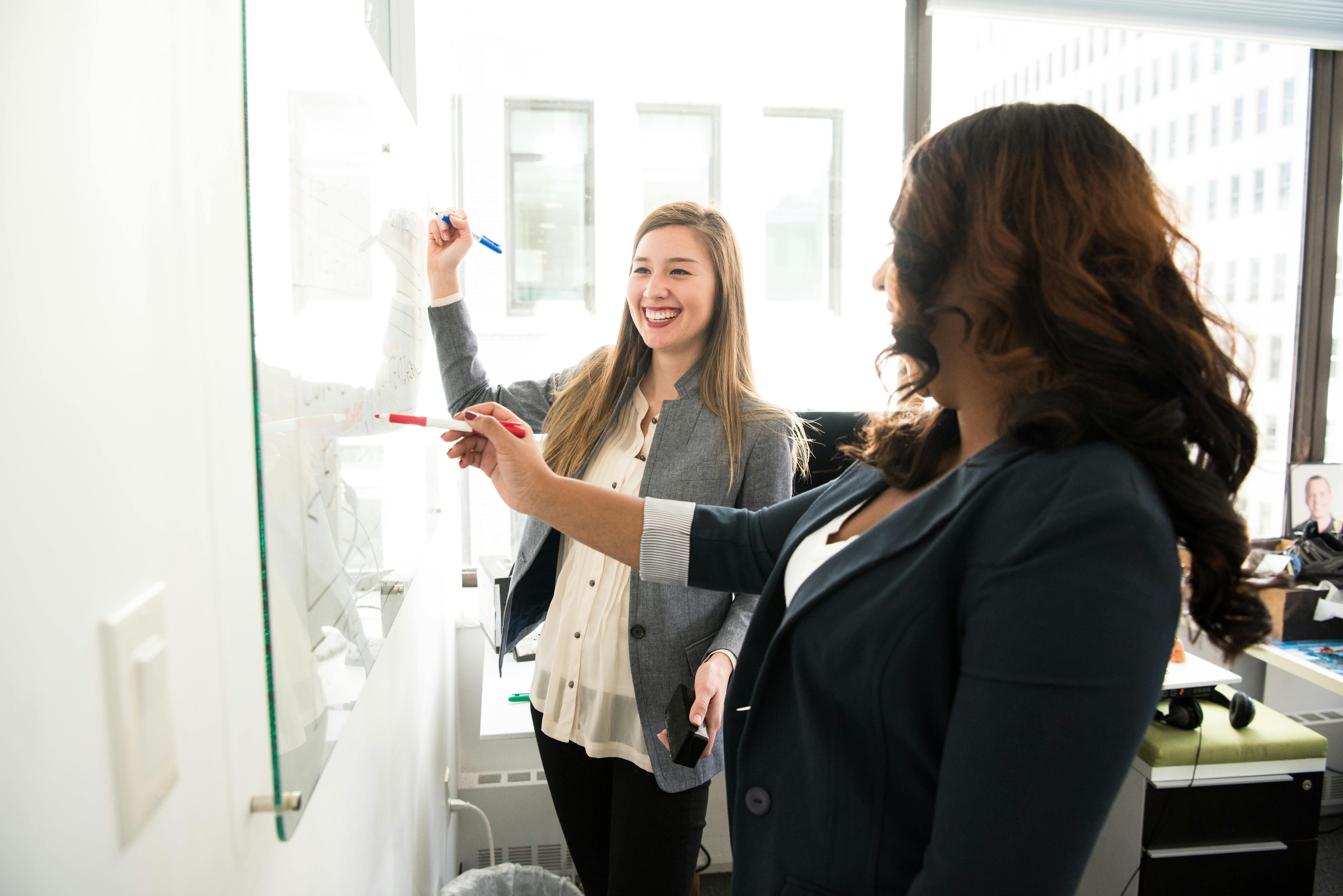 two leaders working at a whiteboard