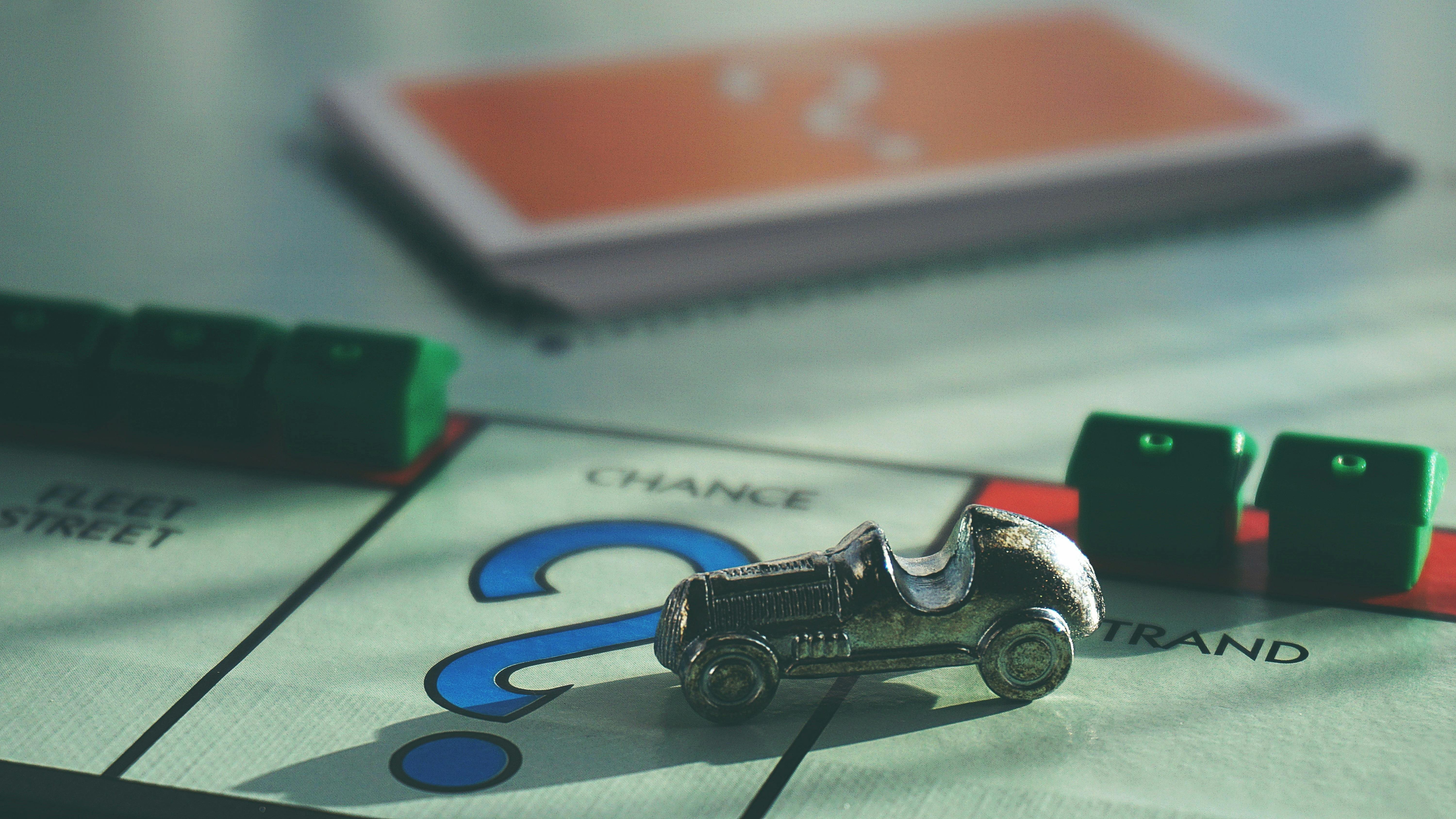 a close up image of a Monopoly board game with the car game piece 