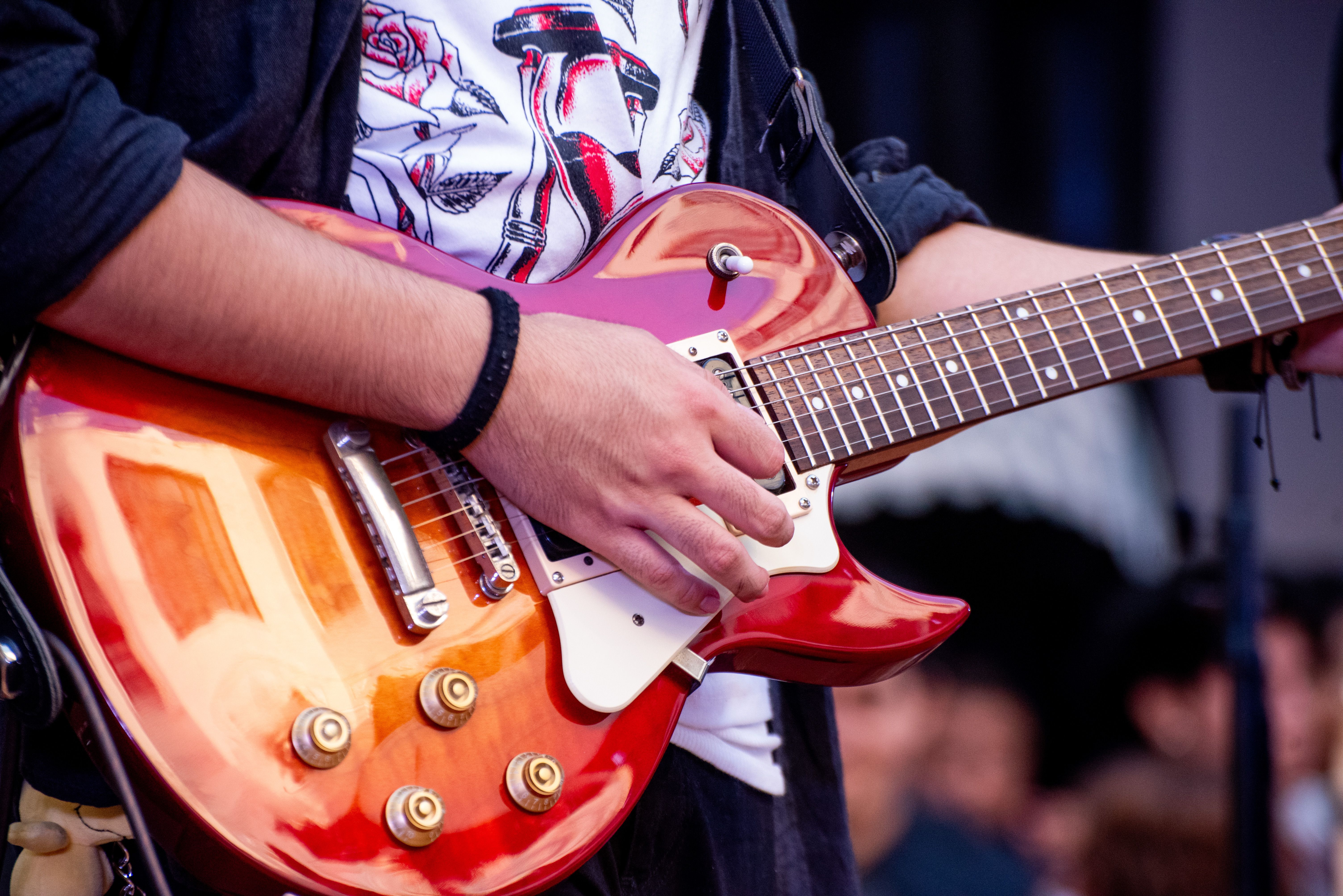 Close-up of a musician playing an electric guitar, symbolizing the connection between music, memories, and personal stories tied to rock ’n’ roll.