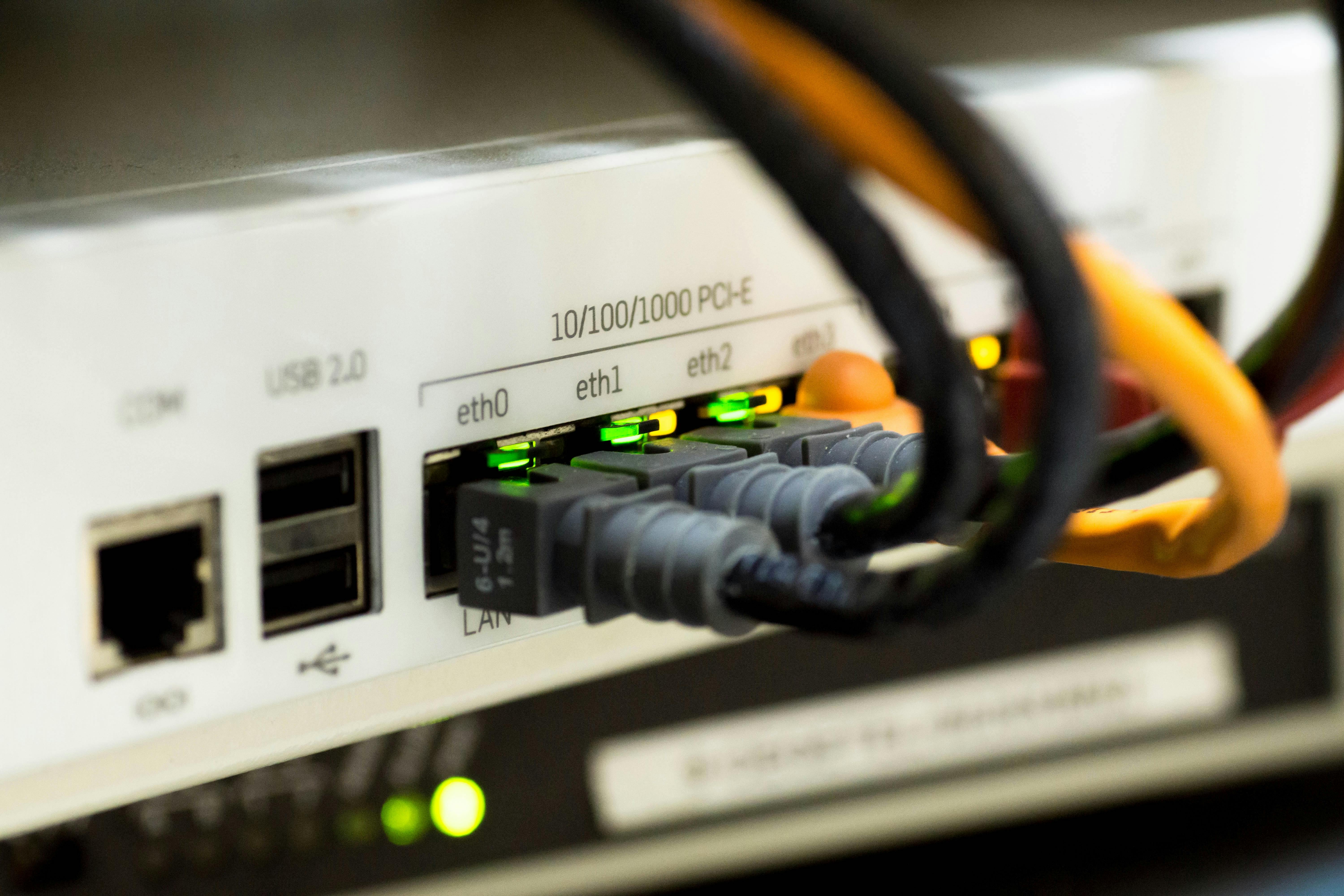 Close-up of a white network switch hub with active green lights, symbolizing operational connectivity and service continuity in critical environments.