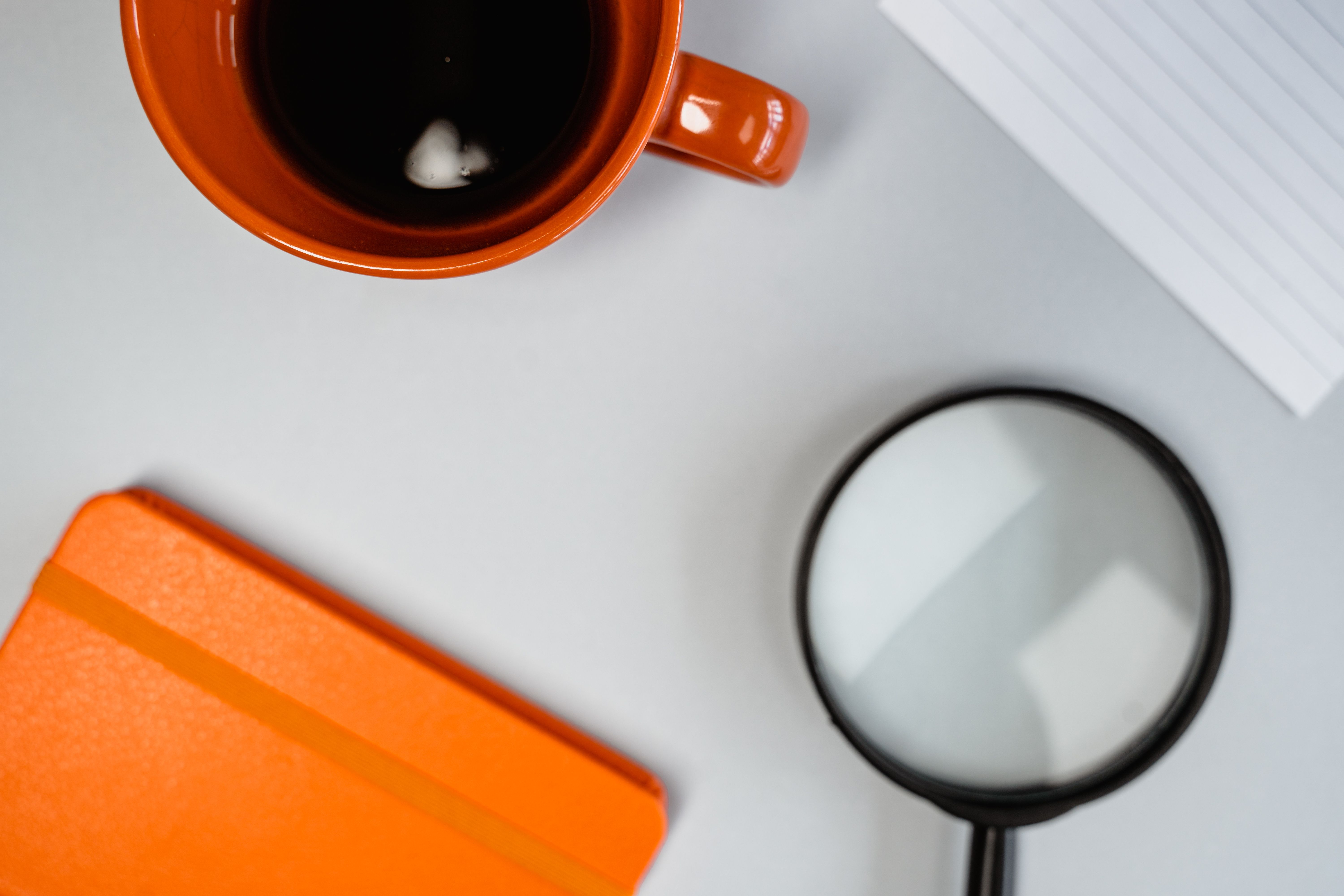 Orange ceramic mug placed on a white surface, symbolizing simplicity and clarity in communication.
