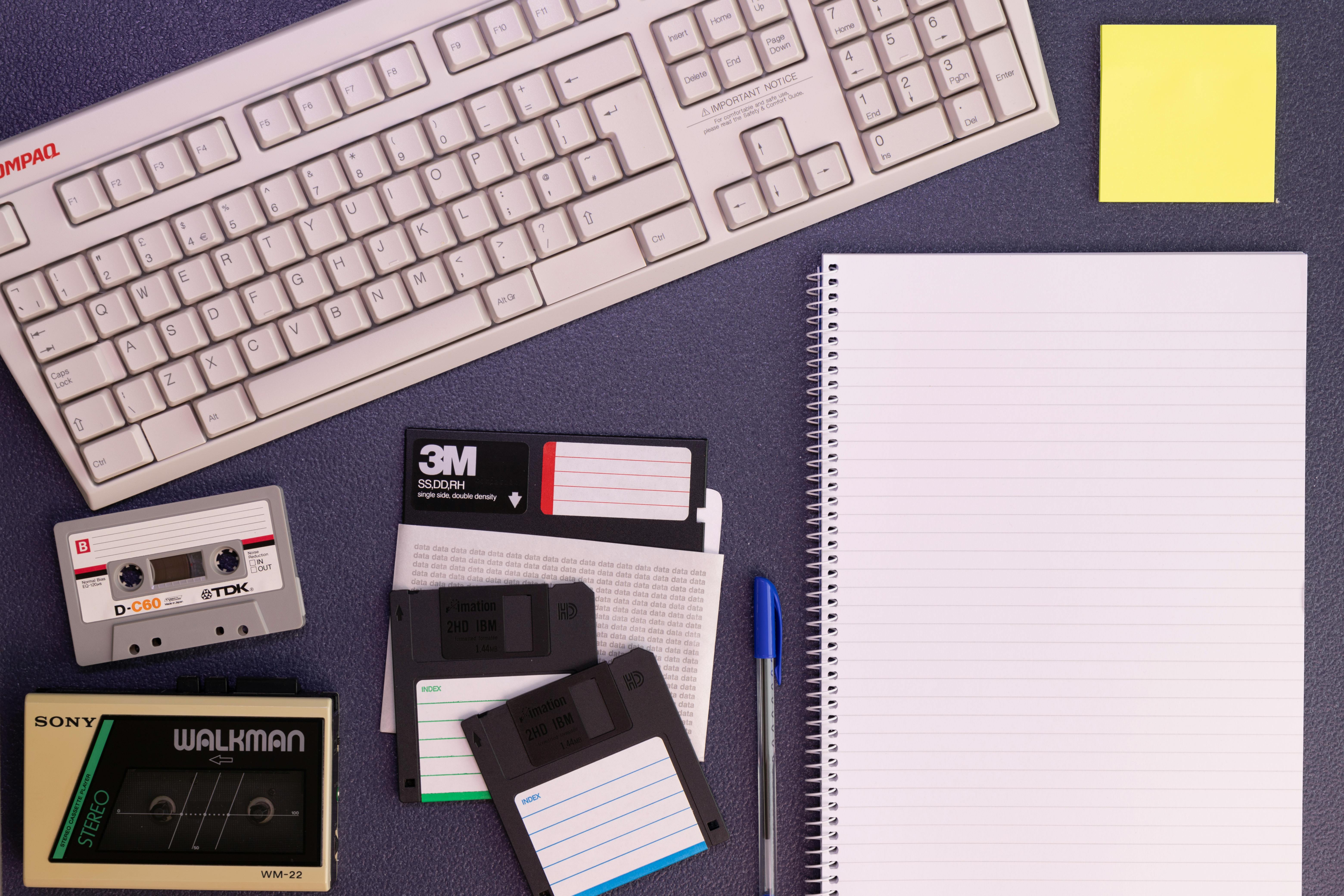 A vintage 1980s desktop computer with a rotary phone and old office supplies, symbolizing outdated processes and legacy systems.