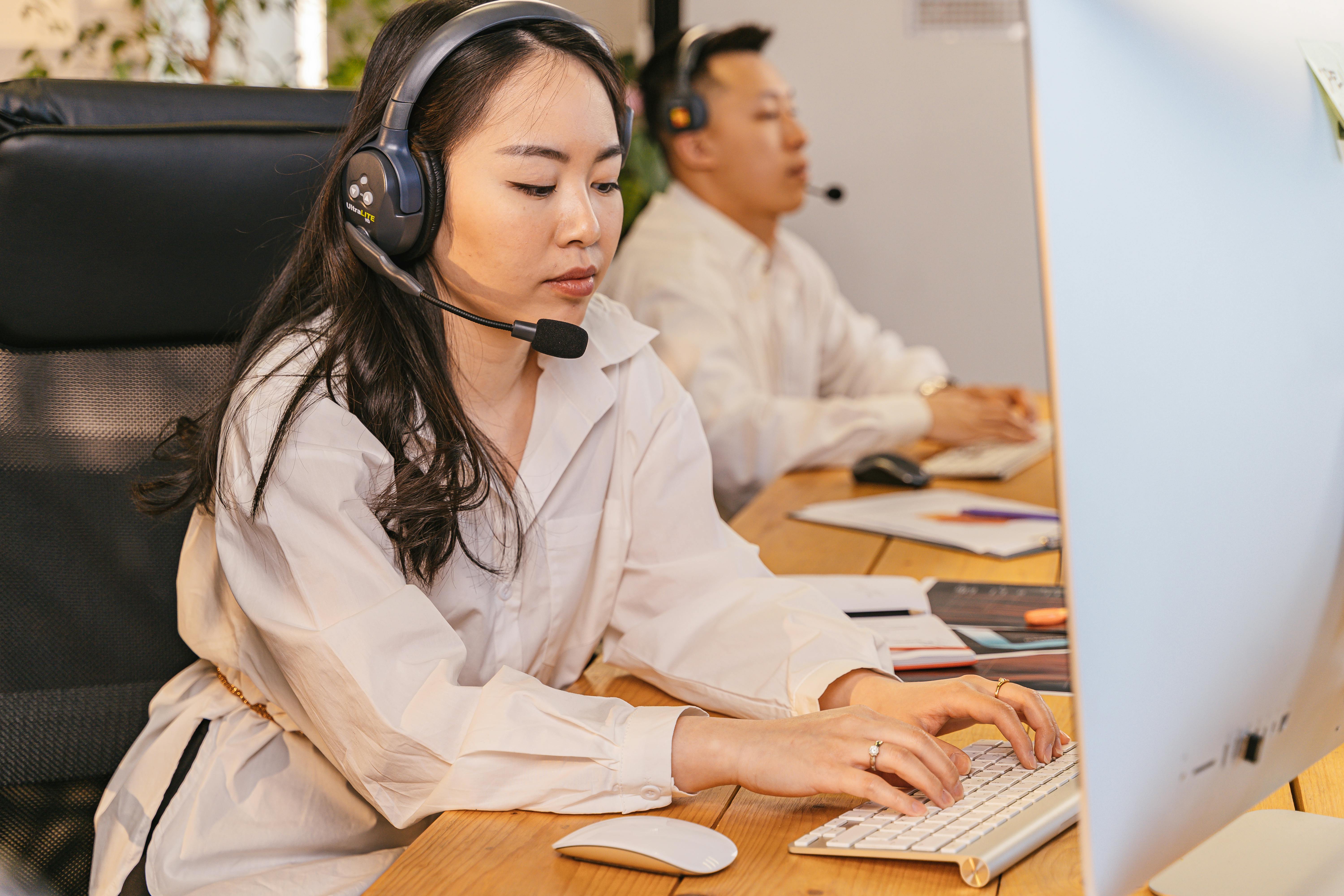 People working in a modern call center office, showcasing teamwork and customer service operations with a focus on efficiency and technology.