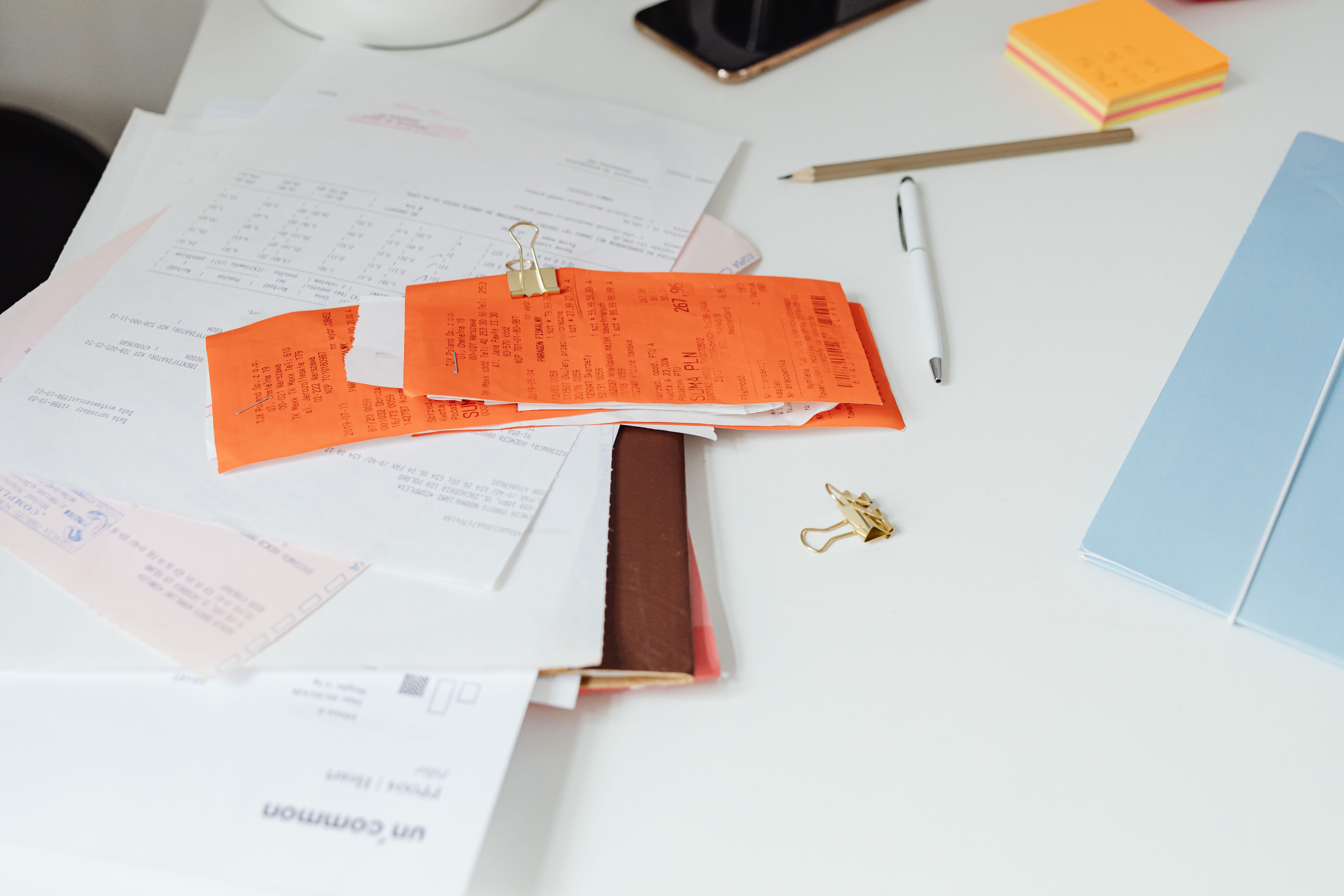 Receipts and documents scattered on a desk, symbolizing transparency and detailed documentation in the writing process.