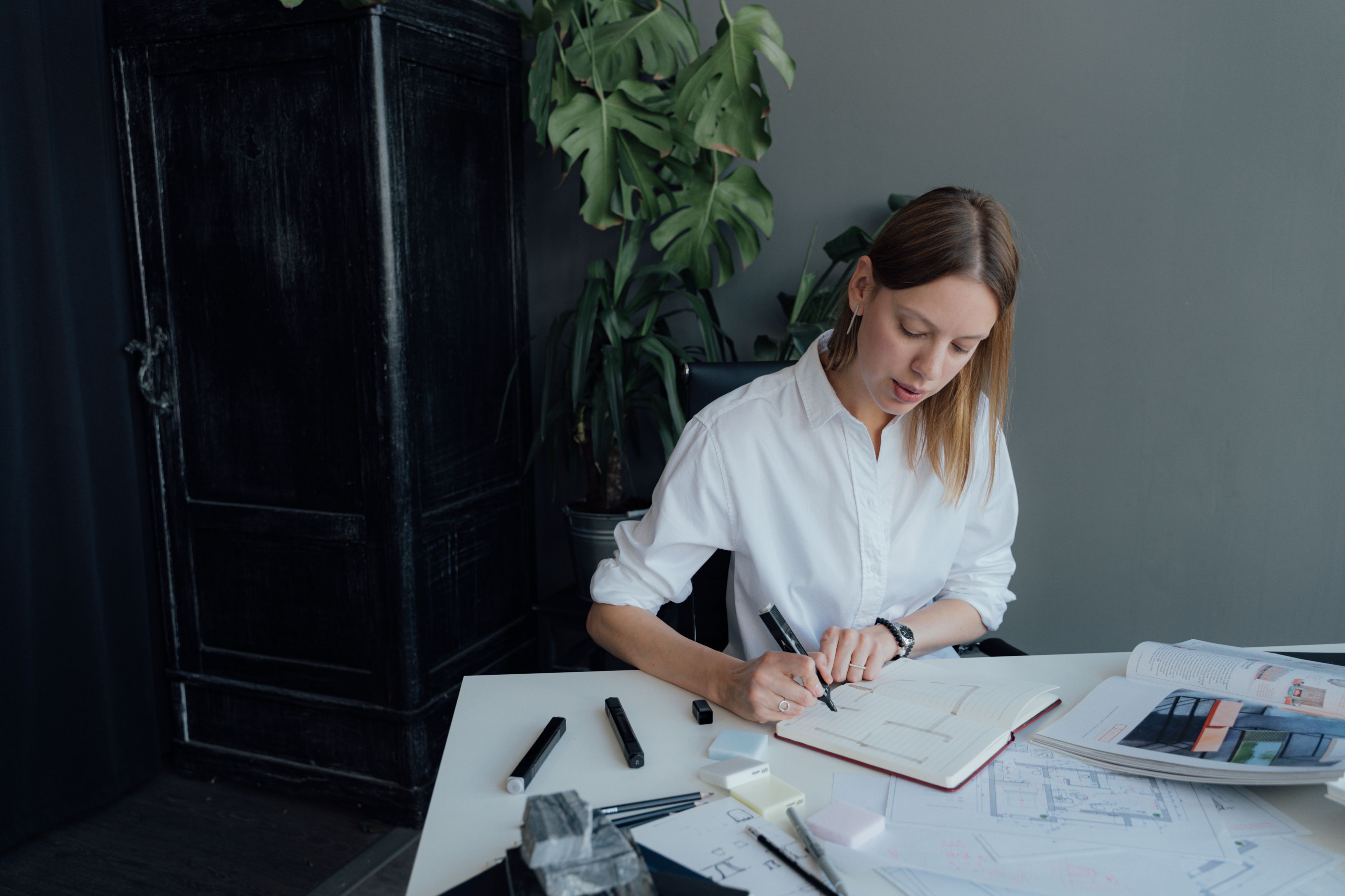 Strategic planning for a contact center, represented by an architect reviewing floor plans at a desk, emphasizing preparation and future-focused initiatives.