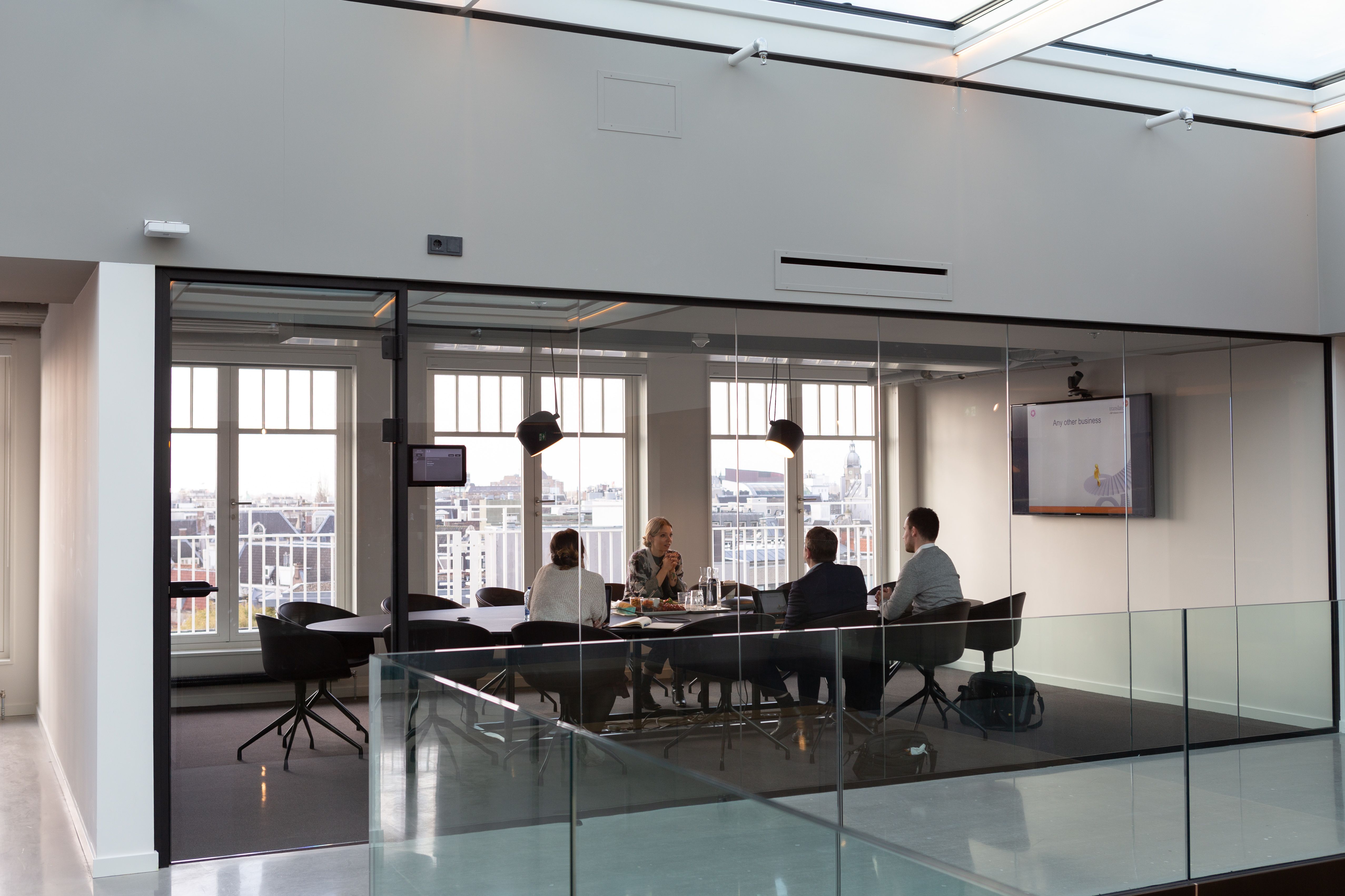 Group of women and men in a meeting at an office, discussing strategies and collaboration, representing teamwork and leadership in customer experience.