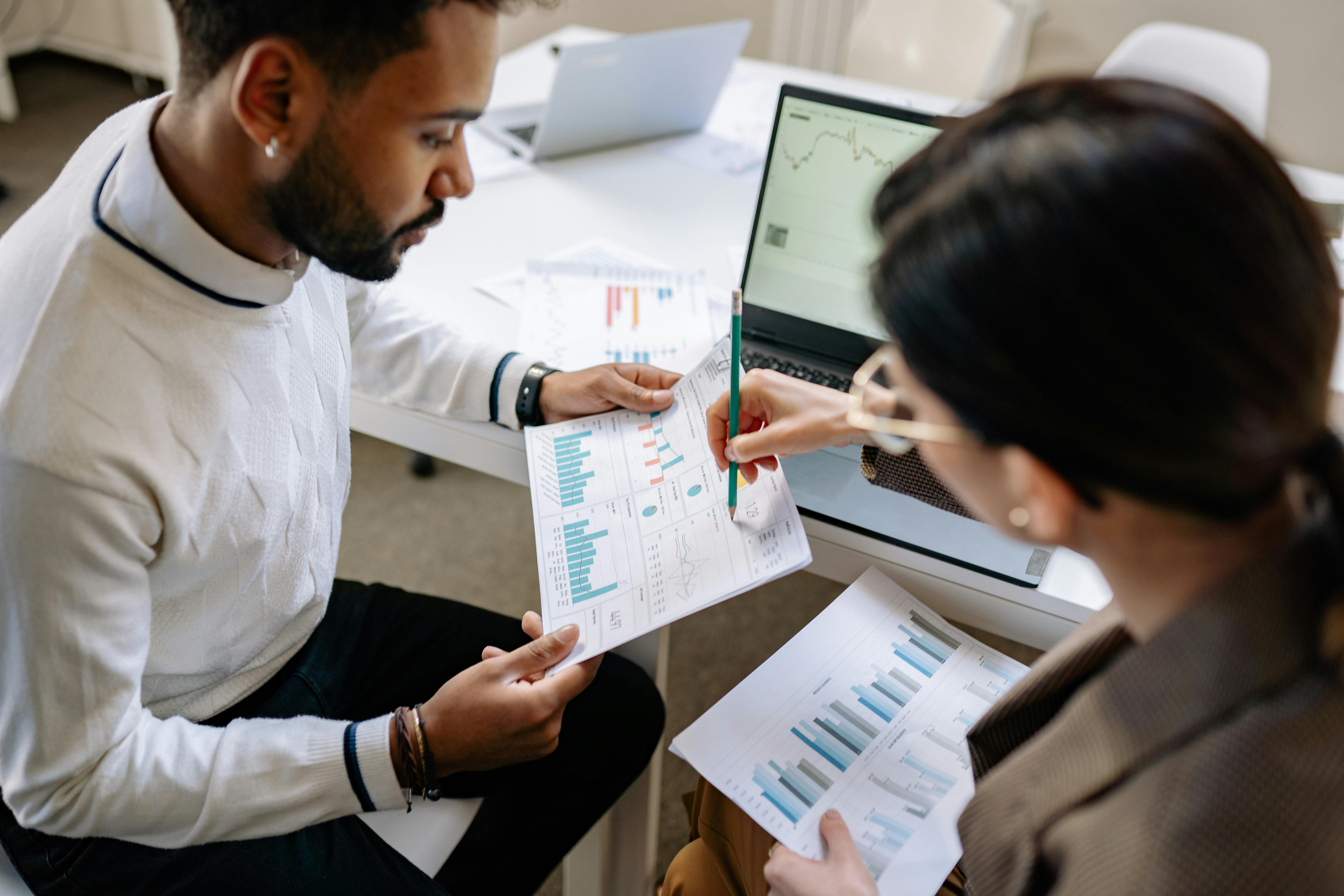 Woman pointing a pencil at a printout while reviewing data, representing contact center data analysis and omnichannel strategy optimization.