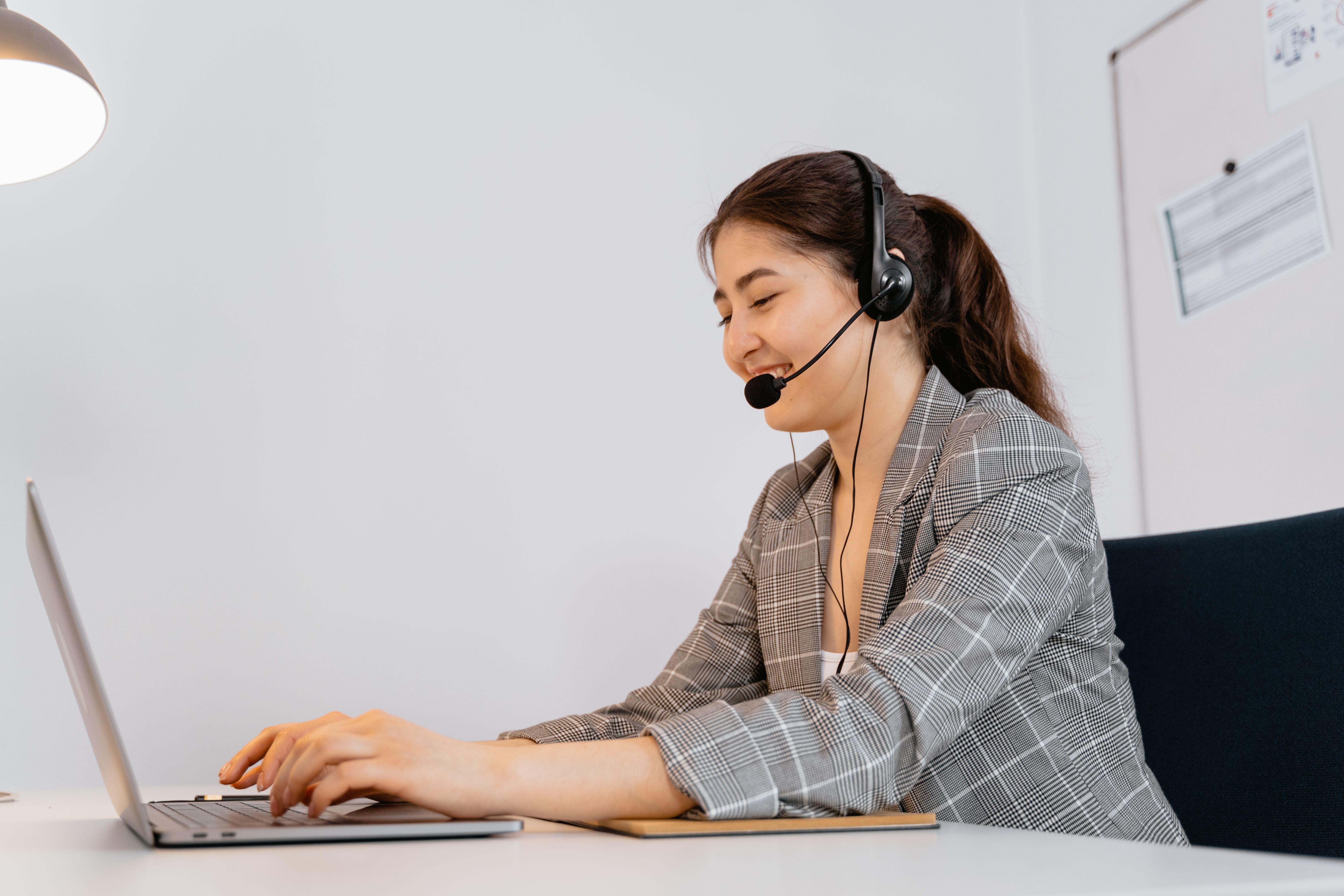 A woman typing on a laptop, symbolizing the balance between AI efficiency and human connection in contact centers